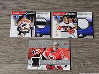 Front view of three NHL trading cards showing jerseys from Paul Coffey, Scott Niedermayer, and Cam Ward with embedded game-used patches.