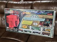 Main box front showing train image and set contents through window, large "Silver Lightning" branding and Bachmann logo.