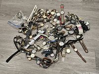 Overhead view of numerous watches laid out on floor