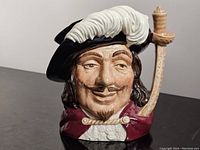 Front view showing detailed face with feathered hat and sword handle