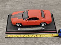 Top and side view of the Maisto 2006 Dodge Challenger Concept model car on black display base.