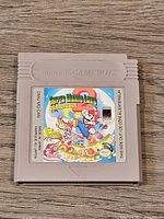Front of the Nintendo Game Boy cartridge showing colorful Super Mario Land 2 label with Mario character and game artwork.