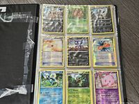 Photo of a binder page showing nine Pokemon cards including Squirtle, Roserade, Munna, and others in plastic protective sleeves