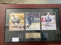 Full view of framed print showing three autographed photos and a plaque naming the players