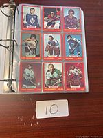 Open binder page displaying nine vintage hockey cards featuring players such as Ron Ellis and Bill Goldsworthy.