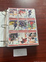 Photo of binder page showing nine hockey cards in plastic sleeves.
