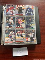Photo showing a binder page with nine hockey cards in plastic pockets, with players in various team uniforms.