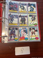 Binder page displaying nine vintage hockey cards in a clear plastic sleeve page