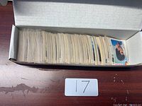 Open white cardboard box filled with hockey cards, cards standing on their sides, with index card labeled 17 in front.