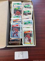 Photo showing a box filled with multiple hockey cards standing upright and tightly packed. Visible cards include Bobby Smith, Bruce Driver, Dave Tippett, Brian Lawton and others.