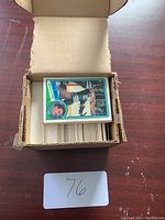 Open cardboard box filled with hockey cards, top card showing Hartford Whalers player