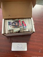 Open cardboard box filled with numerous hockey cards, some visible showing player photos and team logos.