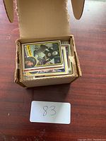 Overhead view of a small cardboard box filled with assorted hockey cards, top card showing a Boston Bruins player.