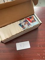Open cardboard box filled with numerous hockey cards stacked upright.
