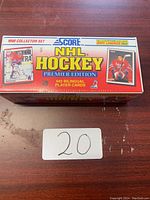 Photograph of the 1990 Score NHL Hockey Premier Edition card set box on a wooden surface with a label marked '20'.