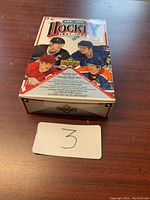 Closed view of the 1990 Upper Deck NHL-LNH hockey trading cards box with images of hockey players on the front.