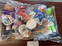 Photo of four Muppets plush toys in original plastic packaging, all dressed in hockey uniforms and holding hockey sticks.