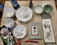 Full lot overview showing Japanese and Polish ceramic dishware, framed picture, Japanese scroll, chopsticks, and iris wall hanging.