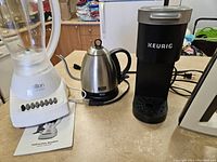 Photo showing Salton Essentials blender, Tru electric kettle, and Mini Keurig coffee maker on countertop with manual visible under blender.