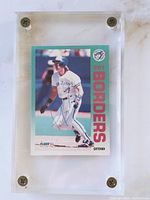Front side of autographed 1992 Fleer Pat Borders baseball card featuring a posed action image of Borders in Toronto Blue Jays uniform, signed in blue ink, encased in clear plastic with metal screws at corners.