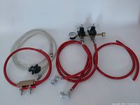 Full kit overview showing gas manifold with two valves, two pressure regulators, connected red hoses, clear beer line and draft beer faucet