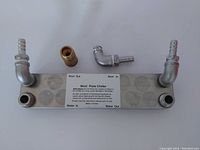 Top view of the stainless steel plate wort chiller with fittings showing the inlet/outlet points and label.