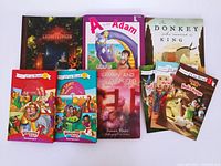 Nine children's bible story books arranged showing front covers with varied colorful illustrations, hard and softcover types included.
