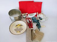 Full lot overview showing all items together including trays, cake pans, pie plate, can opener, grinder, tea pot, bread bags, gravy boat, and mortar and pestle.