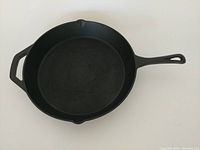 Top-down view of the seasoned cast iron skillet showing interior cooking surface and the two pouring spouts on opposite sides.