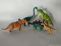 Overview photo showing all five dinosaur toys arranged in a group against a white background, highlighting size and color variations.