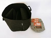 Top view of a large black felt gardening pot containing folded similar pots beside three stacked small grey fabric pots with brand tags.