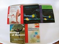 Photo of five medical textbooks arranged in two rows showing titles and cover artwork.