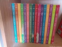 Photo of 16 volumes of The Golden Book Encyclopedia set in a row on a shelf, showing colorful spines with alphabetic volume divisions from A through W-Z.