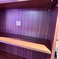 Interior close-up showing the smooth cherry veneer finish on the inside of the bookcase and adjustable shelving holes.