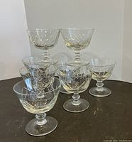 Set of 8 vintage crystal dessert glasses arranged in a stacked pyramid formation, showing the detailed cut pattern and shape.