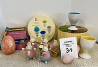 Various pieces of Easter decor including ceramic egg holders, bunny figurines, and containers shown from front angle