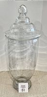 Clear large glass jar with lid, standing upright to show full height and shape.