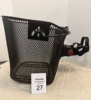 Front angle view of the black metal mesh bicycle basket with mounting bracket, showing the fine mesh and attachment mechanism.