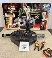 Vintage Star Wars Episode I Lightsaber Duel Game set up in front of original box, includes mounted game figures of Darth Maul and Qui-Gon Jinn and two additional loose figures. Game console has black handles and gray body.