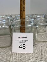 Group of 8 vintage square glass jars arranged in a row with a ruler showing height approximately 5 inches.