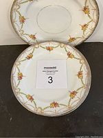 Four vintage lunch plates stacked and displayed, showing floral and gold chain design around edges.