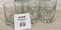 Set of six clear, heavy bottomed whiskey glasses shown in a close-up photo with auction lot number card.
