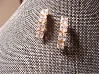 Front view of 10K gold earrings showing four square-cut clear stones vertically lined.