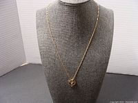 Full view of the necklace with heart pendant displayed on a bust stand.