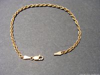 Full view of the 8-inch gold rope chain bracelet with lobster clasp on dark background