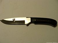 Full view of Ducks Unlimited Cutter fixed blade knife showing blade with deer head cutout and black handle with engraving.