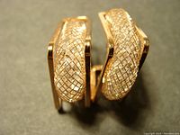 Pair of rose gold colored clip-on earrings with mesh over glass in a rectangular frame