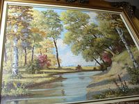 Framed oil painting of a landscape with trees and water under a partly cloudy sky.
