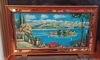 Full view of vintage framed scenic print showing island castle and surrounding landscape with mirrored wooden frame.