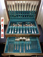 Full set of knives and cutlery slots in the upper and middle compartments of the silver chest with turquoise velvet lining